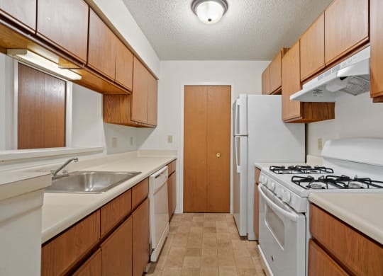 a kitchen with white appliances and wooden cabinets at Beacon Hill and Great Oaks Apartments, Illinois