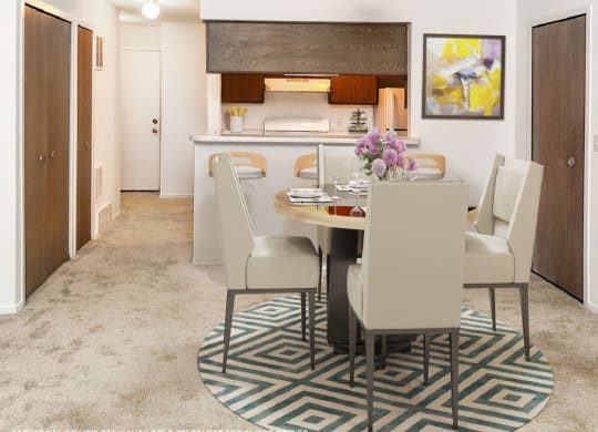 a dining area with a table and chairs and a kitchen in the background  at Northport Apartments, Michigan, 48044