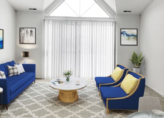a living room with blue couches and yellow pillows  at Northport Apartments, Michigan