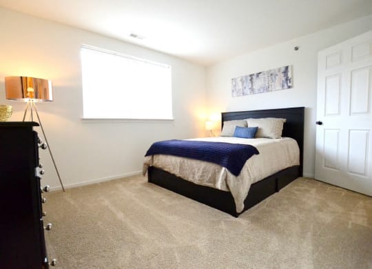 a bedroom with a bed and a window at Northport Apartments, Macomb