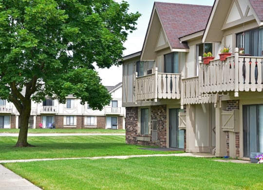 a picture of an apartment complex with a tree in the foreground at Beacon Hill and Great Oaks Apartments, Rockford