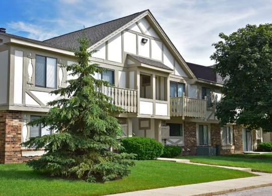 an apartment building with two large trees in front of it at Beacon Hill and Great Oaks Apartments, Rockford, IL, 61109