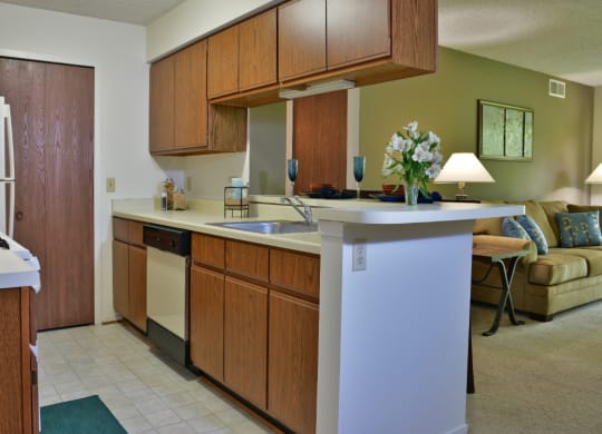 a kitchen with wooden cabinets and a white counter top at Beacon Hill and Great Oaks Apartments, Illinois, 61109