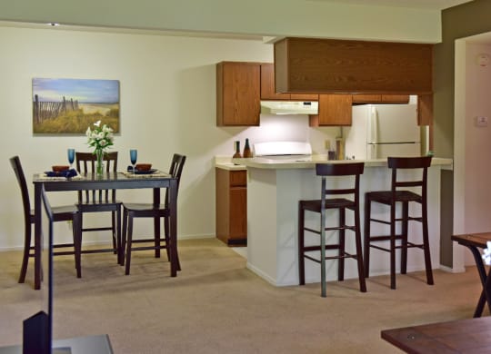 an open kitchen and dining area with a dining table and chairs at Beacon Hill and Great Oaks Apartments, Rockford, IL