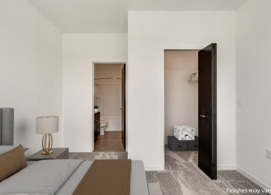 a bedroom with a bed and a door that leads to a bathroom  at Uptown Square Apartments, Michigan