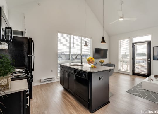 a kitchen with a large island and a view of a living room  at Uptown Square Apartments, Troy, MI