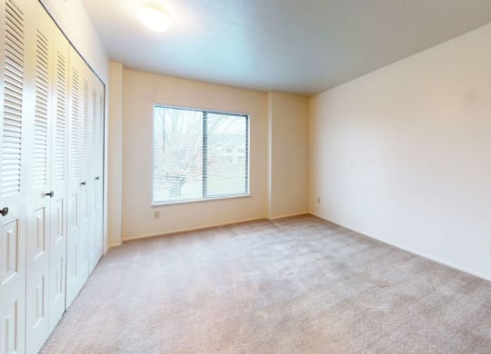 spacious bedroom with a large window and closet at Pine Knoll Apartments, Battle Creek, 49014