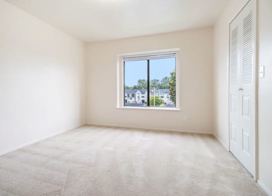 spacious bedroom with a window and a closet at Pine Knoll Apartments, Battle Creek, MI