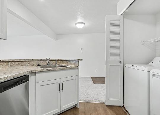 A kitchen with a laundry area with a washer and dryer at Pine Knoll Apartments, Battle Creek