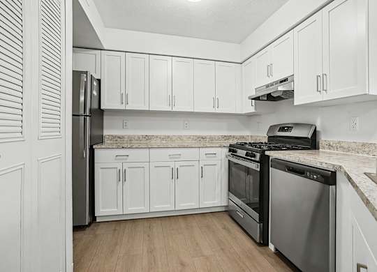 A kitchen with white cabinets and stainless steel appliances at Pine Knoll Apartments, Battle Creek