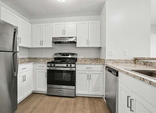 A kitchen with white cabinets and stainless steel appliances at Pine Knoll Apartments, Battle Creek