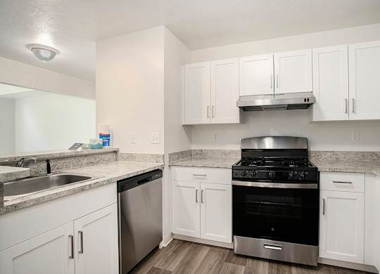 A kitchen with white cabinets and stainless steel appliances at Pine Knoll Apartments, Battle Creek, 49014