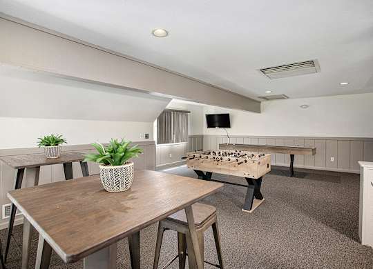 A loft inside the community building with a foosball table and a long table with chairs at Pine Knoll Apartments, Michigan, 49014