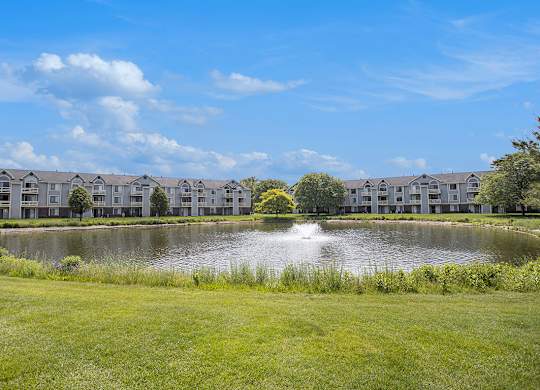 A serene pond with a fountain at Pine Knoll Apartments, Michigan, 49014