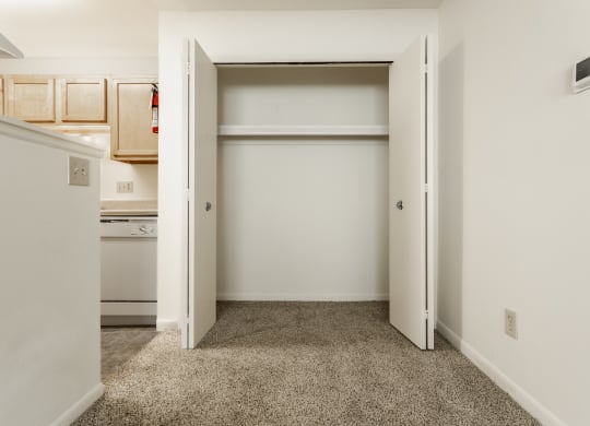 a bedroom with an open closet and a kitchen at Polo Run Apartments, Greenwood, Indiana