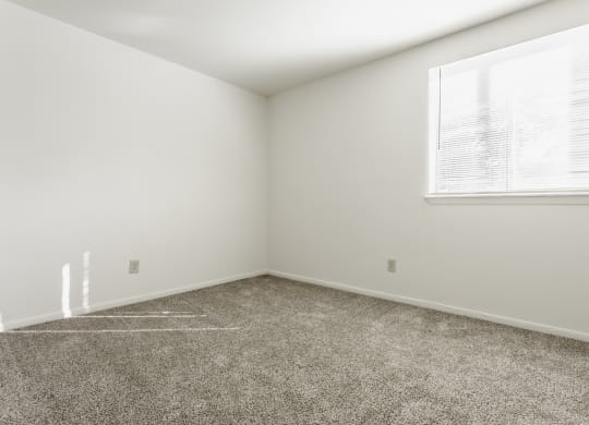 an empty room with carpet and a window at Polo Run Apartments, Greenwood, Indiana