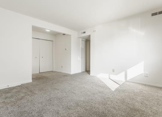 an empty living room with white walls and tile floor at Polo Run Apartments, Indiana