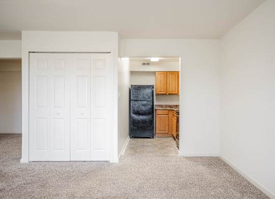 A white door is on the left and a black fridge is on the right at Polo Run Apartments, Greenwood, 46142