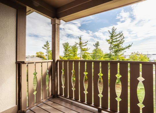 a balcony with a view of a blue sky and trees at Polo Run Apartments, Indiana