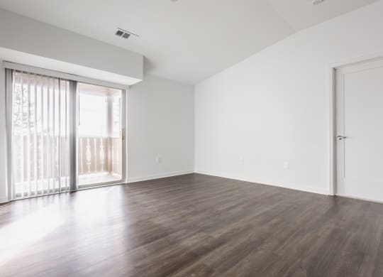 an empty living room with wood floors and a sliding glass door at Polo Run Apartments, Indiana, 46142