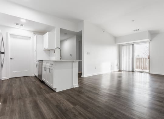 the living room and kitchen in a new home with white walls and wood flooring at Polo Run Apartments, Indiana