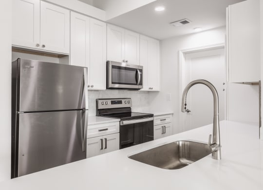 a white kitchen with stainless steel appliances and a sink at Polo Run Apartments, Indiana, 46142