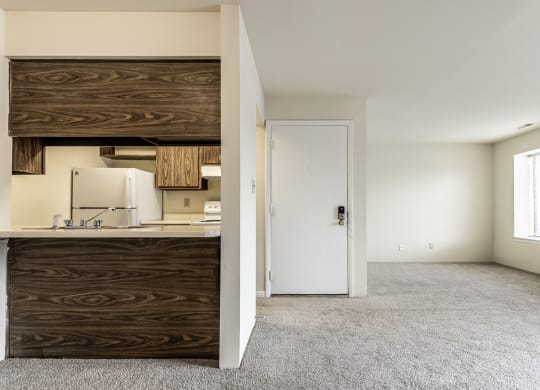 an empty living room with a kitchen and a door to a white room at Scarborough Lake Apartments, Indianapolis, 46254