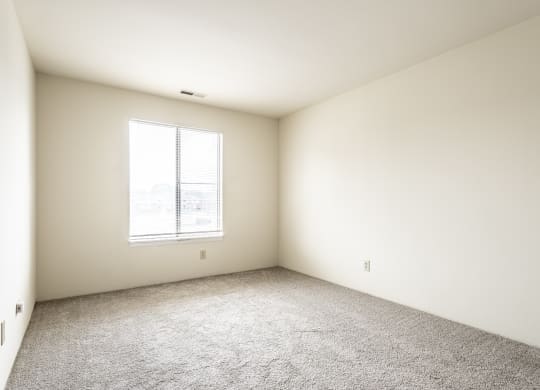 an empty room with carpet and a window at Scarborough Lake Apartments, Indianapolis, IN
