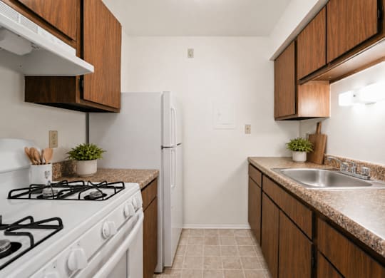 A kitchen with a white gas stove and a white refrigerator.
