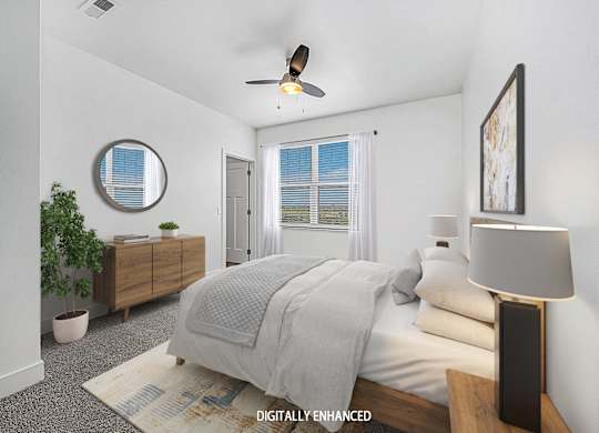 A bedroom with a bed, a ceiling fan, and a window with blinds at The Reserve at Destination Pointe apartments, Grimes, IA