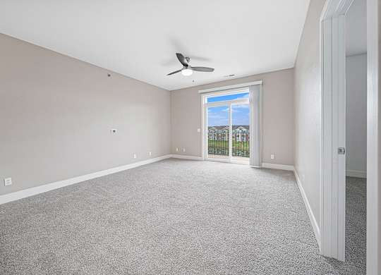 A living room with a 9' ceiling and ceiling fan at The Reserve at Destination Pointe, Iowa
