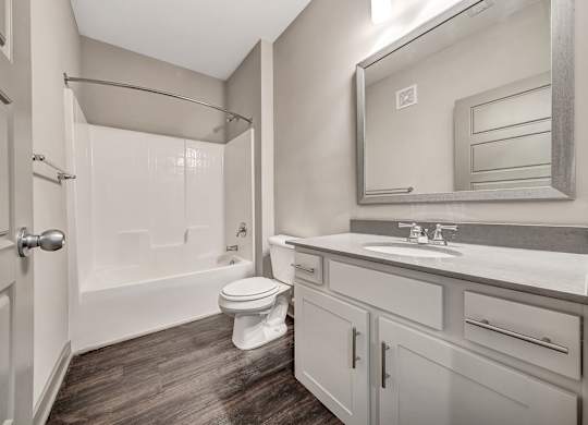 A bathroom with a toilet, sink, and shower. at River Crossing Apartments, Missouri, 63303