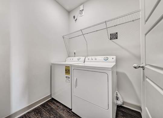 A white washer and dryer in a laundry room. at River Crossing Apartments, St. Charles, 63303
