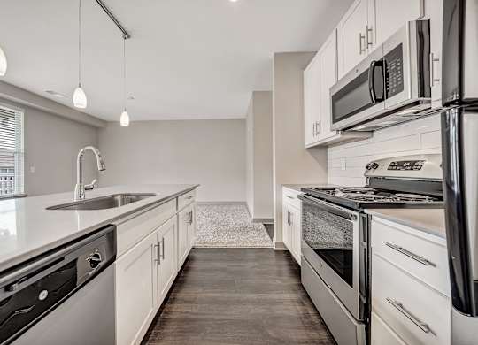 A modern kitchen with stainless steel appliances and white cabinets.at River Crossing Apartments, St. Charles, 63303