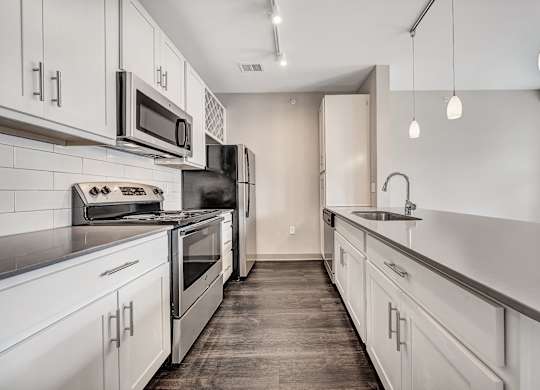 A kitchen with white cabinets and stainless steel appliances.at River Crossing Apartments, St. Charles, 63303