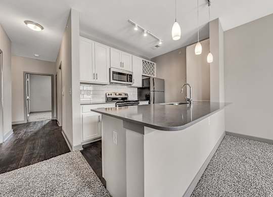 A modern kitchen with a white countertop and cabinets.at River Crossing Apartments, Missouri, 63303