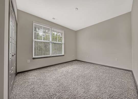 A room with a window and carpeted floor.at River Crossing Apartments, St. Charles, MO, 63303