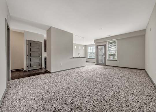 A spacious empty room with carpeted floor and white walls. at River Crossing Apartments, St. Charles, Missouri