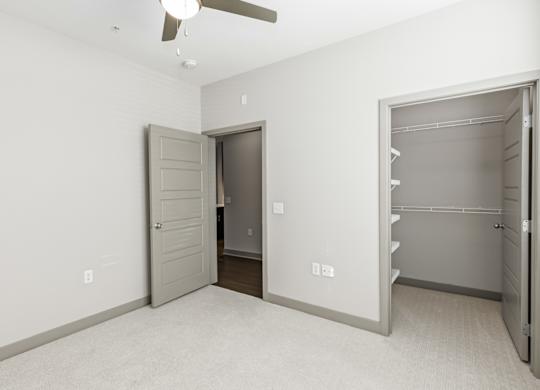 A room with a ceiling fan and two open doors. at River Crossing Apartments, Missouri, 63303