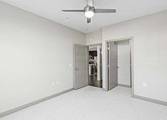 A room with a ceiling fan and two doors. at River Crossing Apartments, Missouri