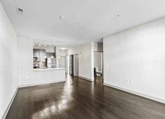 A spacious room with wooden floors and white walls. at River Crossing Apartments, Missouri, 63303