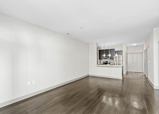 A spacious room with wooden floors and white walls. at River Crossing Apartments, St. Charles, Missouri