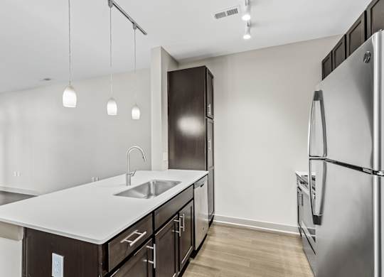 A modern kitchen with a white countertop and stainless steel appliances. at River Crossing Apartments, St. Charles, 63303