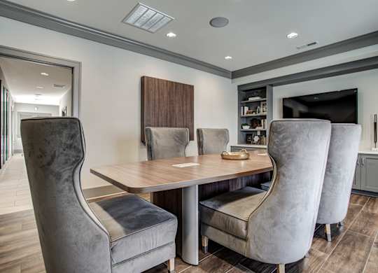 A modern dining room with a wooden table and grey chairs. at River Crossing Apartments, Missouri, 63303