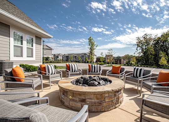 A patio with a fire pit and chairs. at River Crossing Apartments, Missouri