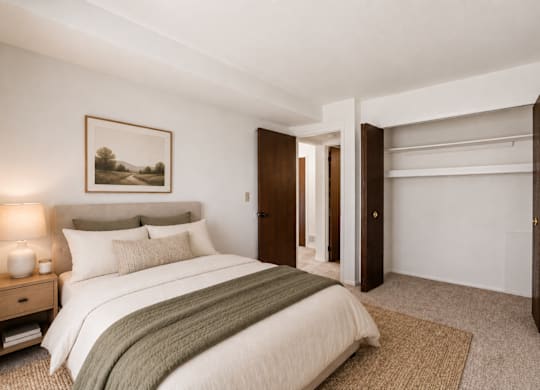 A bedroom with a large bed and a painting on the wall.