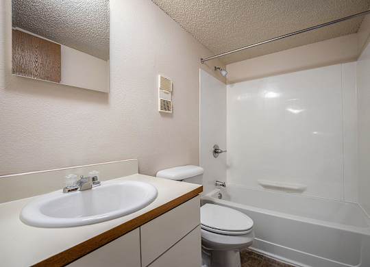 A toilet, sink, bathtub, and mirror in a bathroom at Seville Apartments, Michigan