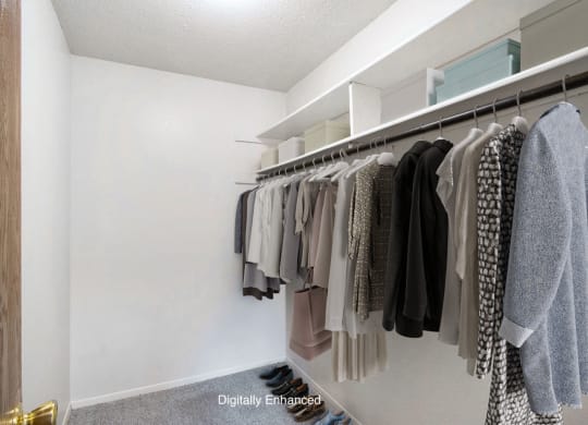 a walk in closet with a rack of clothes at Seville Apartments, Kalamazoo, MI, 49009