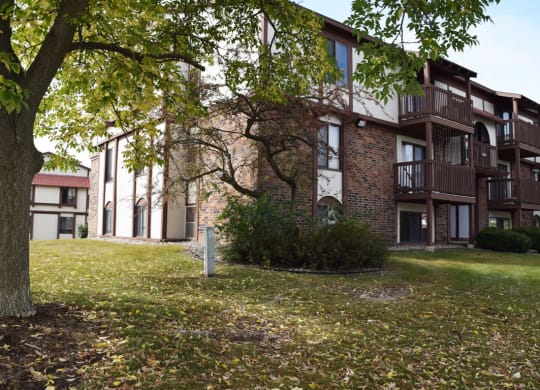 the courtyard of an apartment building with mature shade trees at Seville Apartments, Michigan