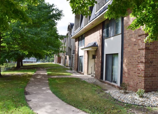 a sidewalk in front of a brick apartment building at Seville Apartments, Michigan